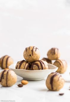 a white bowl filled with chocolate chip cookie doughnuts on top of a table