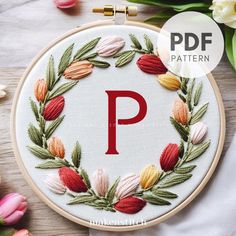 a embroidery pattern with the letter p on it and flowers in the background, including tulips