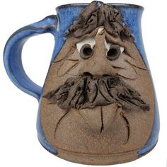 a blue and brown vase with a face drawn on it