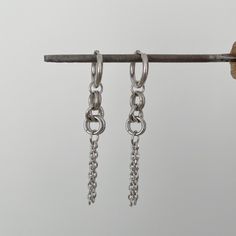 Add an edgy touch to your everyday look with these stunning chain earrings in stainless steel. These versatile earrings are perfect for adding a minimalist yet modern flair to any outfit. Handcrafted with high-quality stainless steel, they are durable, hypoallergenic, and will last for years to come. Whether you're heading to work or a night out with friends, these chain earrings are sure to make a statement. Treat yourself or a loved one to these chic and trendy earrings that are sure to become Edgy Sterling Silver Dangle Earrings, Minimalist Metal Hoop Earrings With Chain, Trendy Silver Hoop Earrings With Adjustable Chain, Silver Chain Earrings For Everyday, Sterling Silver Earrings With Adjustable Chain For Everyday, Modern Hypoallergenic Dangle Cartilage Earrings, Edgy Everyday Metal Earrings, Hypoallergenic Metal Drop Cartilage Earrings, Trendy Metal Drop Cartilage Earrings