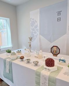 a white table topped with lots of cakes and desserts