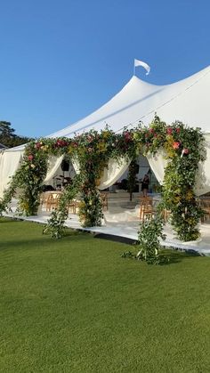 a large white tent covered in flowers and greenery