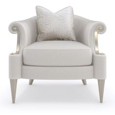 a white chair with a pillow on top of it and some silver trim around the armrests