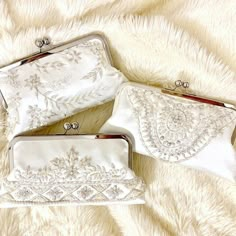 three white purses sitting on top of a furry surface