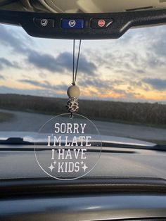 a car dashboard with a keychain hanging from it's side window that says sorry i'm hate i have kids