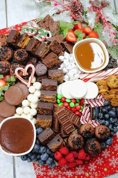 a platter filled with chocolate, marshmallows, cookies and other treats