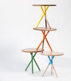 three wooden shelves stacked on top of each other with different colored sticks sticking out of them