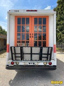 the back end of a white truck with orange doors