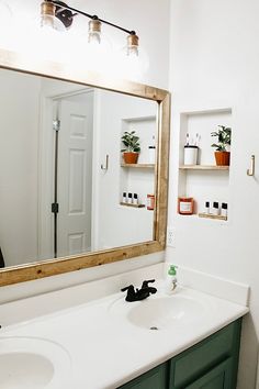 a bathroom with two sinks and a large mirror over it's counter top area