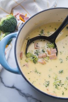 broccoli and ham soup in a blue pot with a black spoon