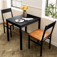 two chairs and a table with food on it in front of a potted plant