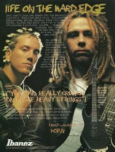 two men with dreadlocks and guitars in front of an advertisement for the band