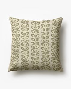 a green and white pillow with leaves on it