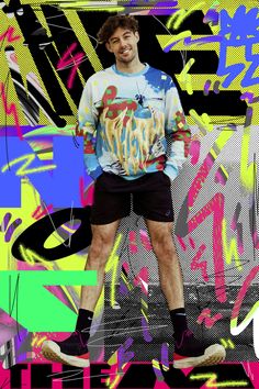 a man is standing on a skateboard in front of colorful wallpaper and graffiti