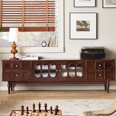 a living room scene with focus on the sideboard and chess pieces in front of it