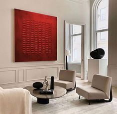 a living room filled with furniture and a large red painting on the wall above it