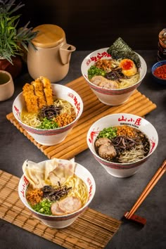 three bowls filled with different types of food next to chopsticks and a teapot