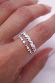 a woman's hand with two rings on it and one is wearing a diamond ring