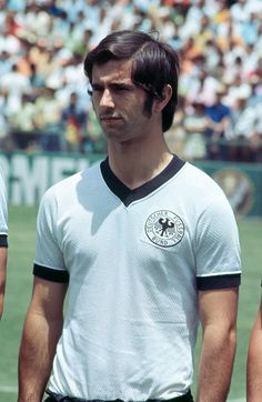 two men standing next to each other in front of a crowd at a soccer game