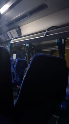 the inside of a bus with blue seats and lights on it's ceiling is empty