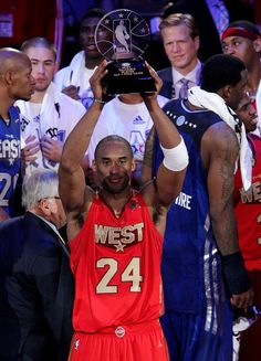 the basketball player is holding up his trophy