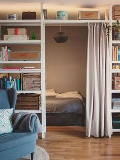 a living room filled with furniture and bookshelves next to a bed in a bedroom