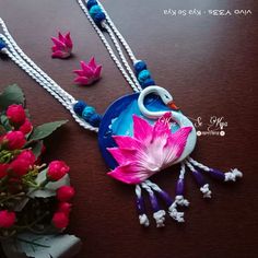 two necklaces that have flowers on them and one is decorated with an image of a swan