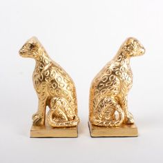 two gold colored animal figurines sitting side by side