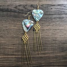 two heart shaped earrings on top of a wooden table