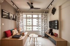 a living room filled with furniture next to a window covered in black and white curtains