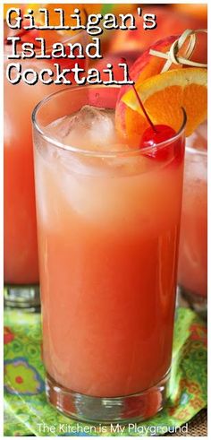 a close up of a drink in a glass with an orange garnish on the rim