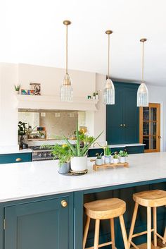 a kitchen with blue cabinets and stools