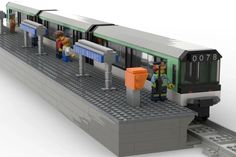 a lego model of a subway station with people waiting on the platform to board it