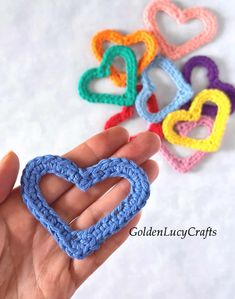 crochet hearts are being held in the palm of someone's hand