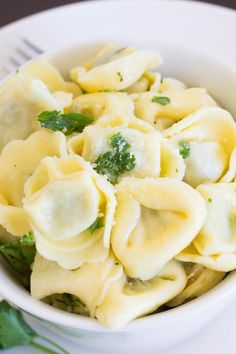 a white bowl filled with pasta and broccoli