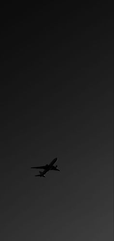 an airplane is flying in the dark sky