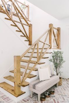 a white couch sitting under a wooden staircase