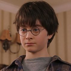 a young boy wearing glasses looking at the camera