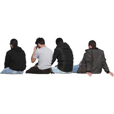 four men sitting on the ground and one is talking on his cell phone while looking at something