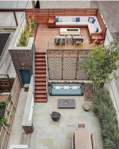 an aerial view of a small backyard with stairs and patio furniture on the ground, surrounded by greenery