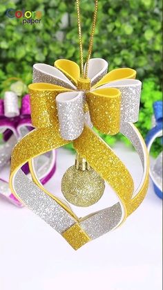 an ornament shaped like a heart with a bow hanging from it's side