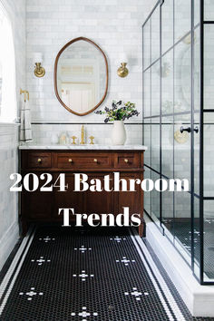 a bathroom with black and white tile flooring and a round mirror above the sink