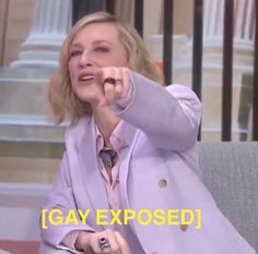 a woman sitting on a couch pointing at something with the caption saying gay exposed