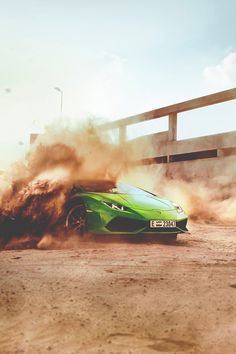 a green sports car is kicking up dirt