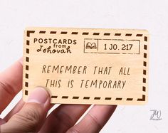 someone is holding up a wooden postcard that says, remember that all this is temporary