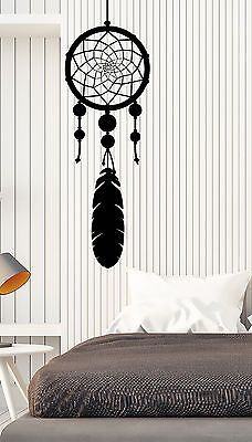 a bedroom with a bed and a wall hanging on the wall next to it is an image of a dream catcher