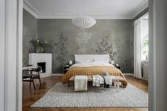 a bedroom with a bed, fireplace and rug on the floor in front of it