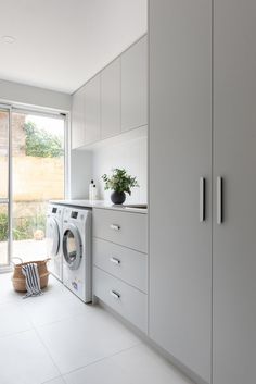 a washer and dryer in a room with white walls, flooring and cabinets