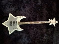 a white electric guitar with an intricate design on it's body and pick up plate