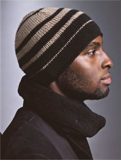 a man wearing a black and white striped beanie with a scarf around his neck